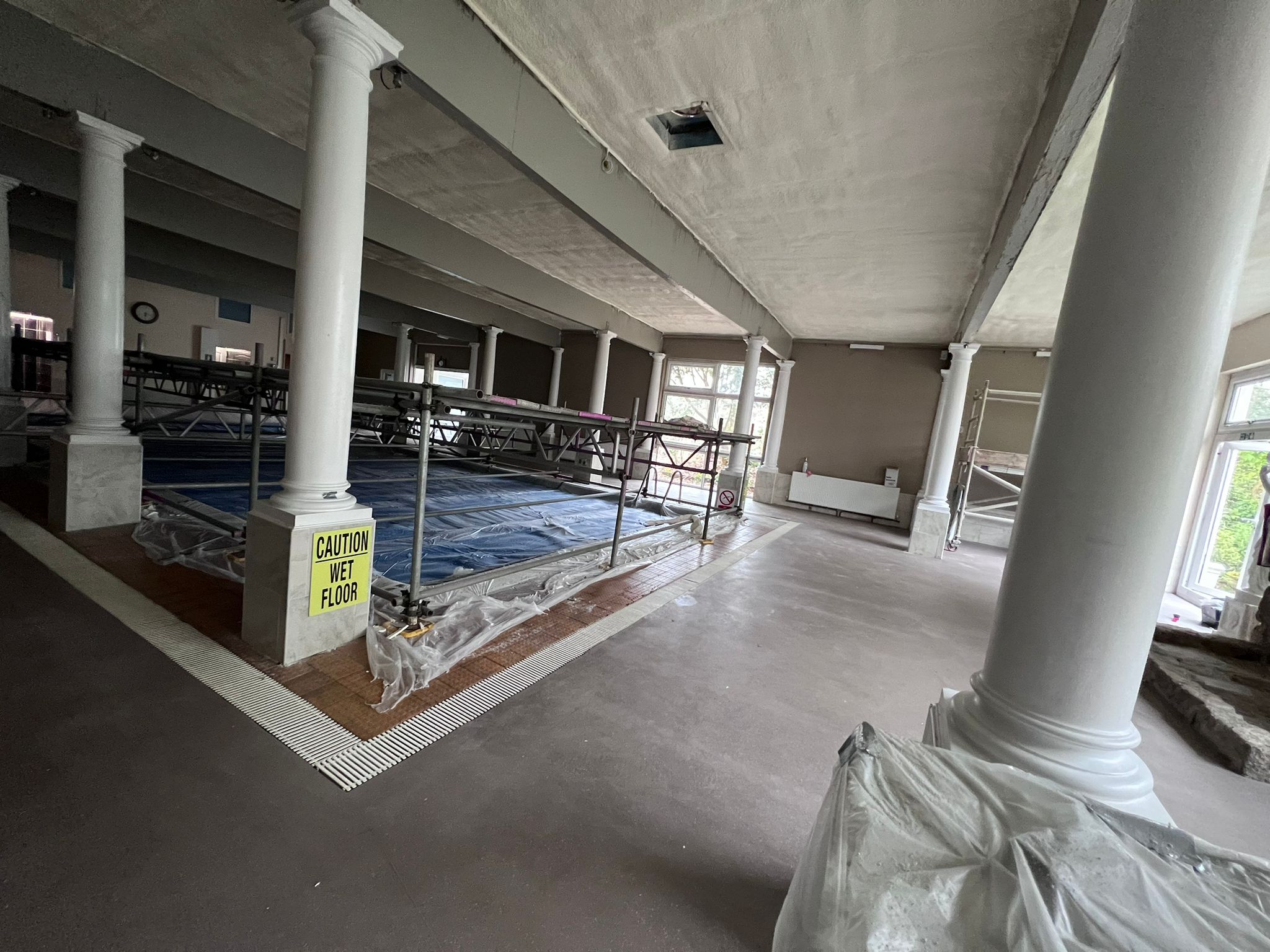 Penventon Hotel pool hall with spray foamed ceiling, columns and pool with blue cover