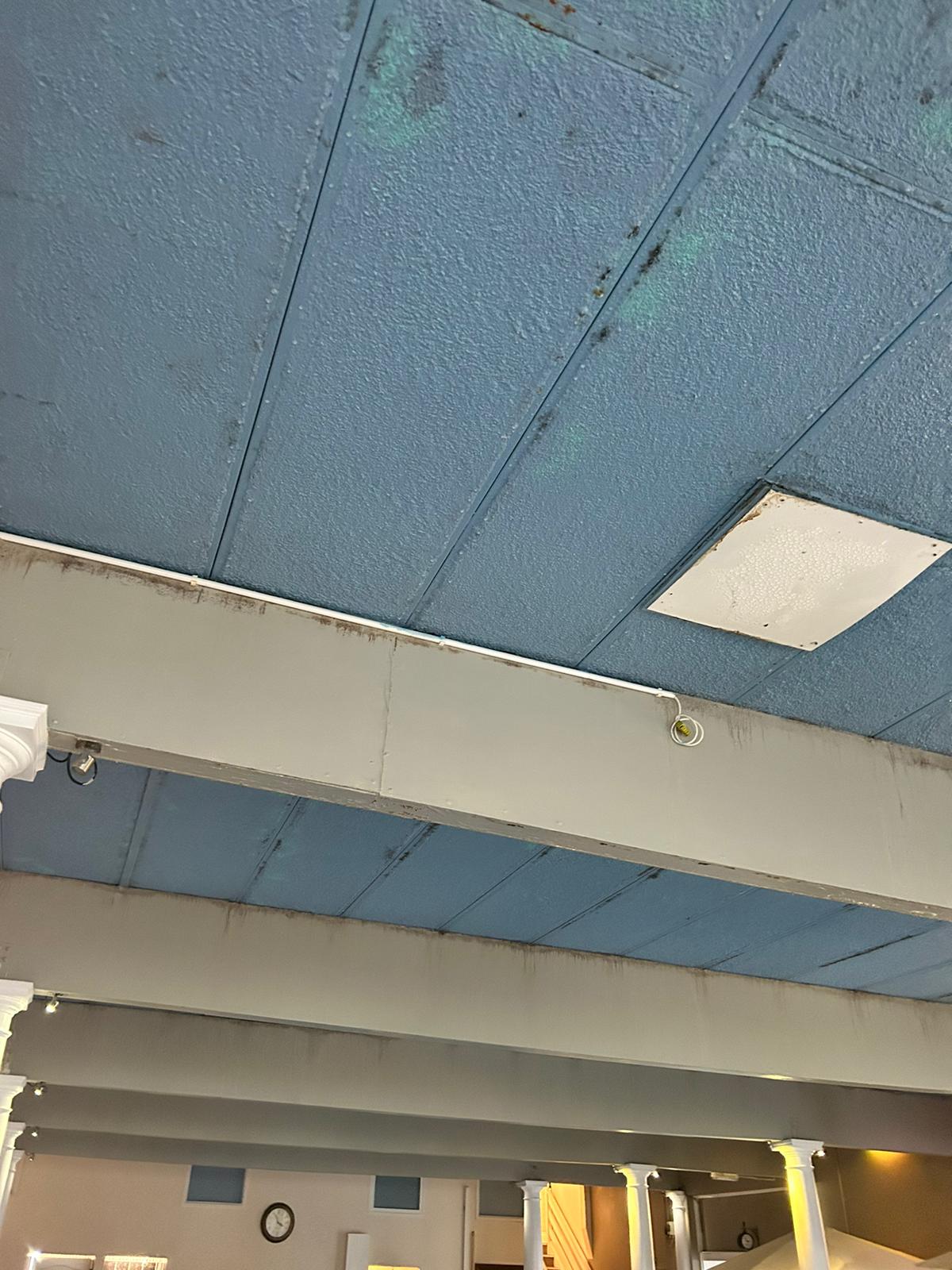 Pre-install pool hall ceiling showing condensation damage to old blue panels
